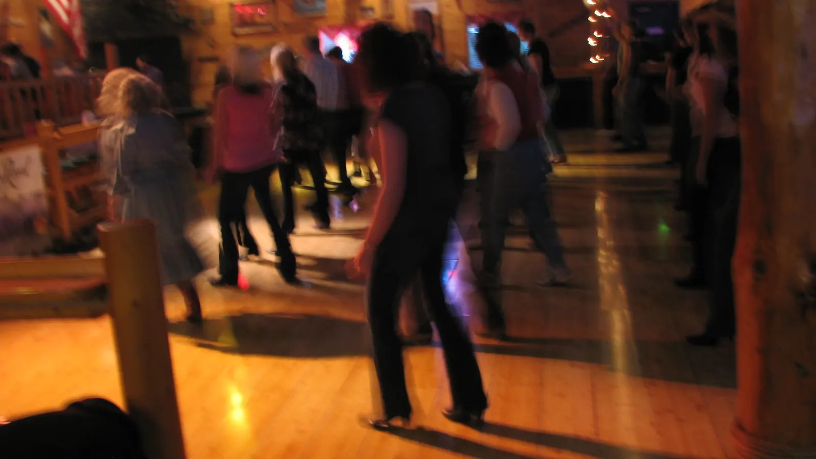 Danseurs en ligne sur un parquet dans une salle de style western, photographie en mouvement